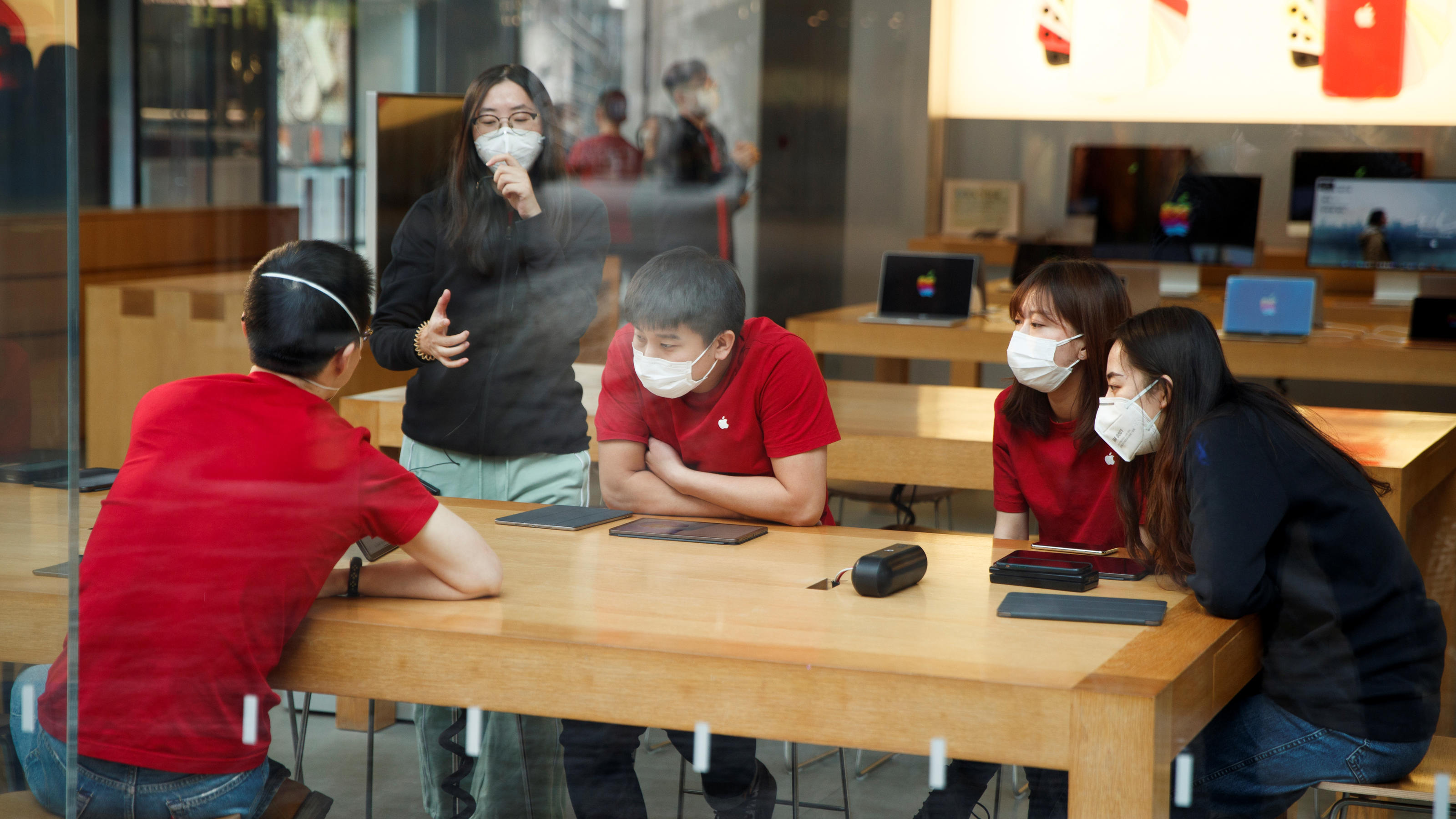 People wear face masks as they listen to a presentation in an Apple Store in the Sanlitun shopping district in Beijing as China is hit by an outbreak of the new coronavirus, January 25, 2020. Picture taken January 25, 2020.   REUTERS/Thomas Peter