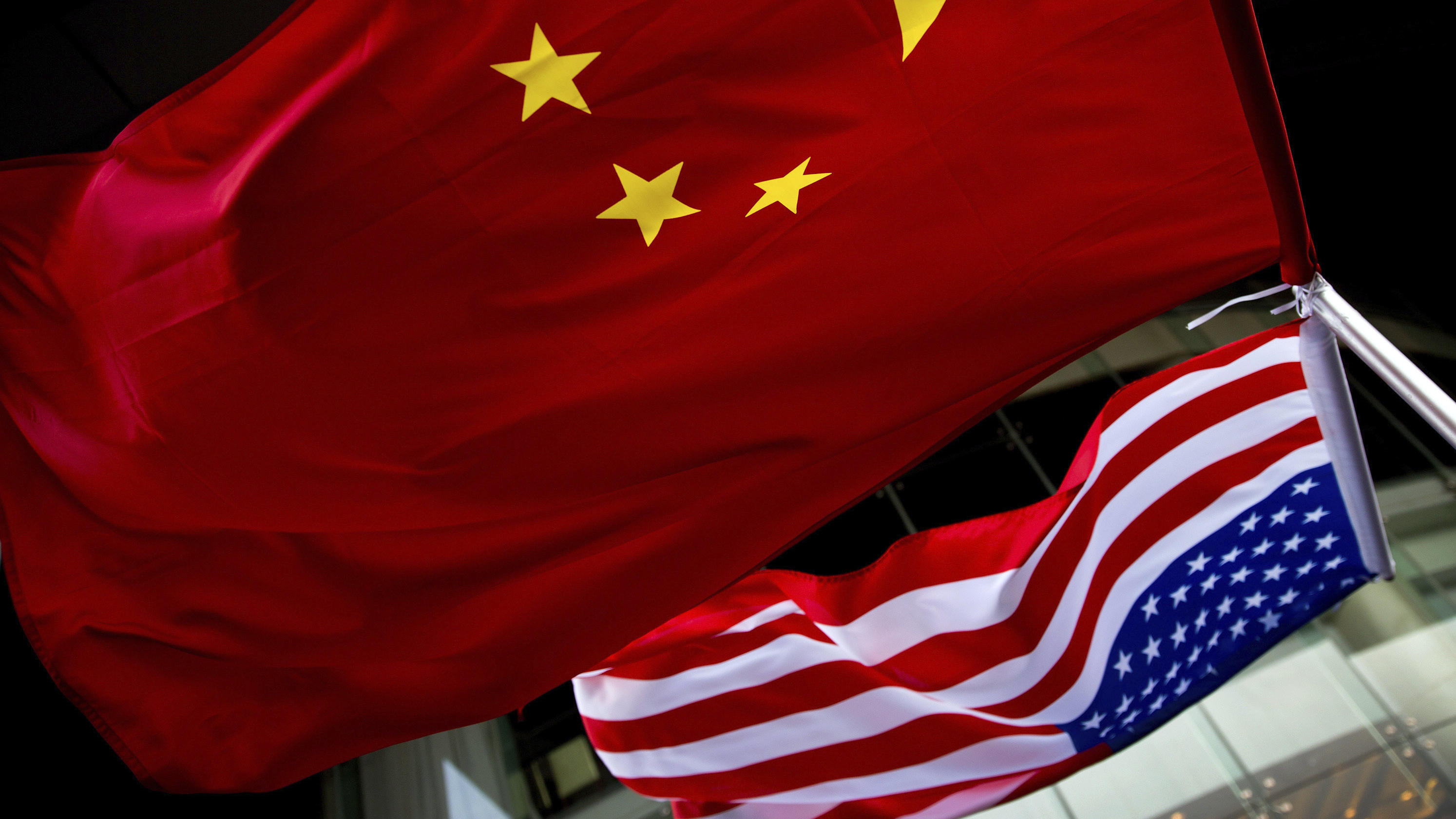 ARCHIV - 07.11.2012, China, Peking: Die US-amerikanische (unten) und chinesische Nationalflaggen wehen vor einem Hotel.    (zu dpa "China und USA wollen erstes Handelsabkommen unterzeichnen") Foto: Andy Wong/AP/dpa +++ dpa-Bildfunk +++