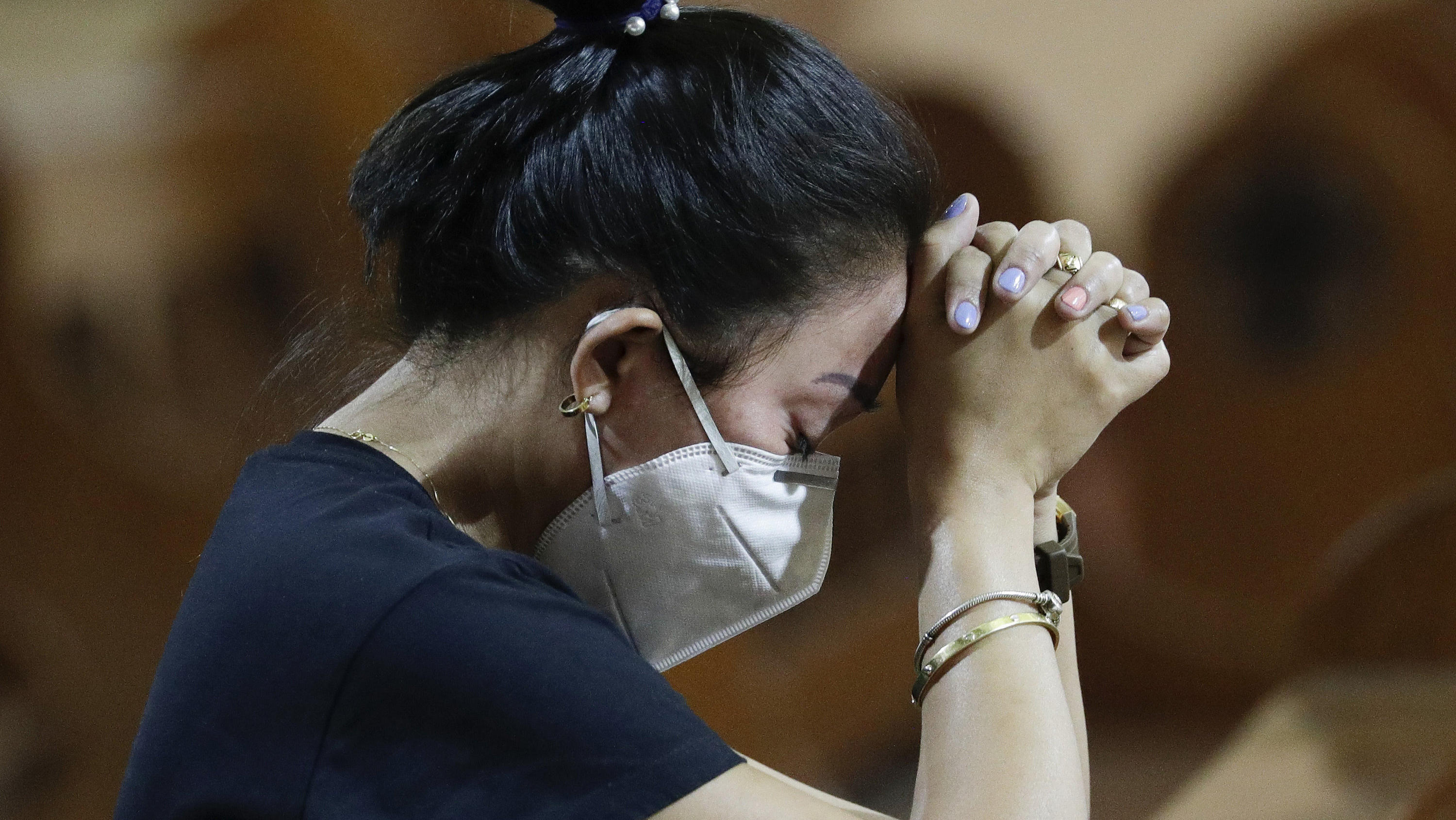 30.01.2020, Philippinen, Manila: Eine Frau mit Atemschutzmaske betet während einer Messe. Die Zahl der Infektionen und Todesopfer durch die Lungenkrankheit aus China ist weltweit erneut gestiegen. Foto: Aaron Favila/AP/dpa +++ dpa-Bildfunk +++