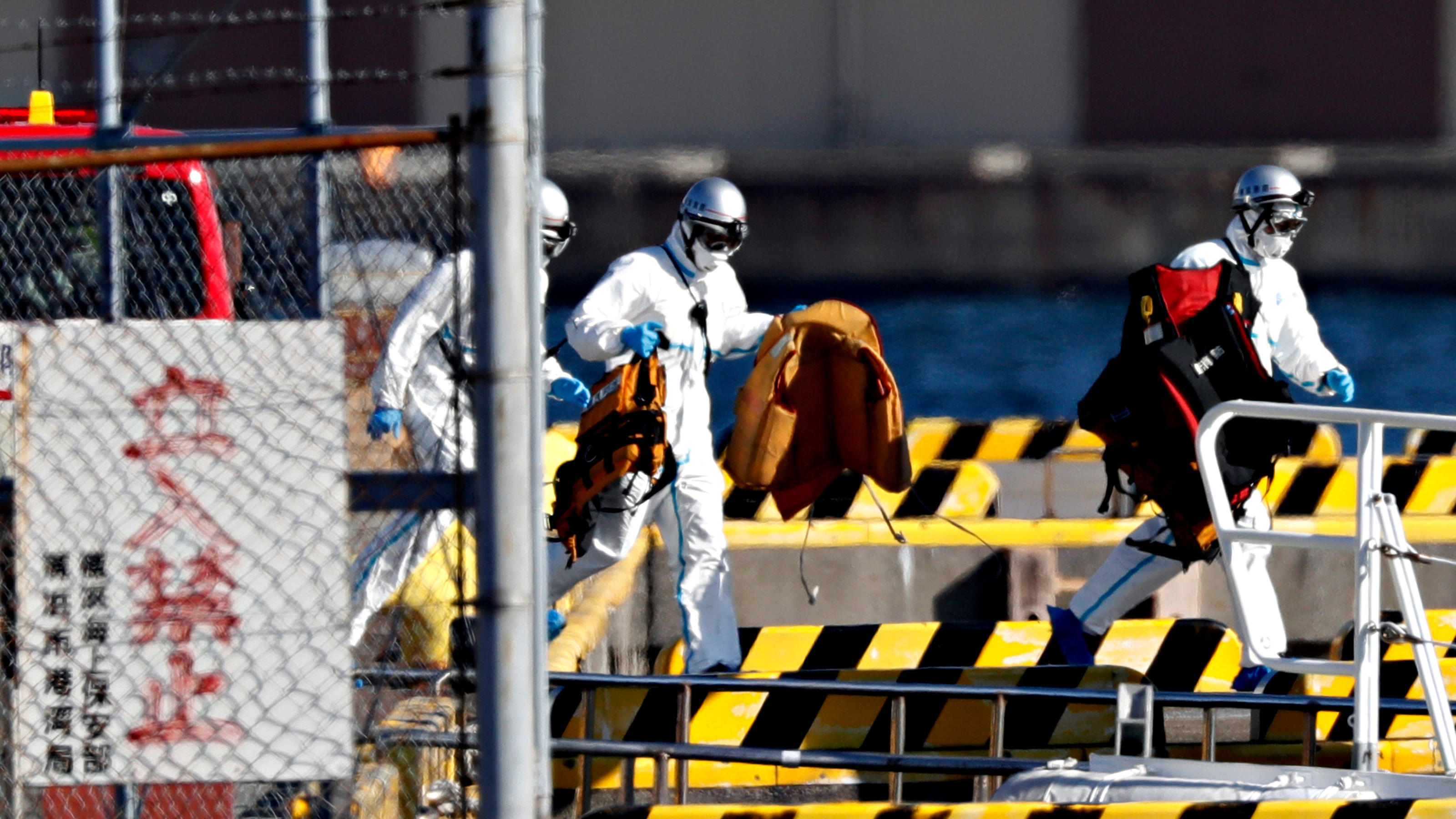Officers in protective gears are pictured at a maritime police's base where people who were transferred from cruise ship Diamond Princess arrived in Yokohama, south of Tokyo, Japan February 5, 2020. REUTERS/Kim Kyung-Hoon