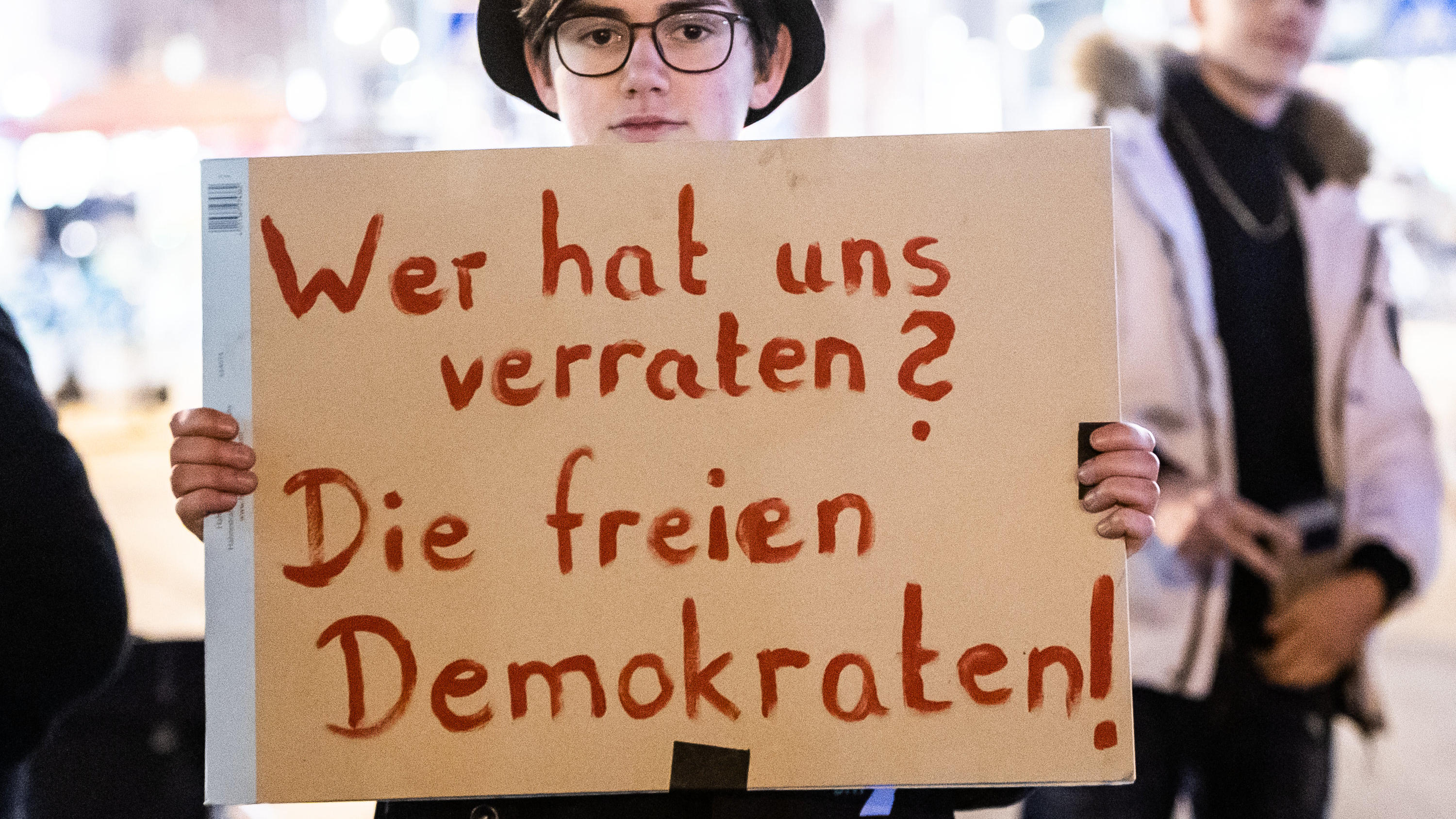 05.02.2020, Hessen, Frankfurt/Main: Eine Teilnehmerin hält bei der Demonstration gegen die Wahl des neuen Ministerpräsidenten von Thüringen ein Plakat mit der Aufschrift «Wer hat uns verraten? Die freien Demokraten!». Kemmerich (FDP) war mit den Stim