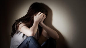 Closeup portrait of depressed teenager girl cover her face.