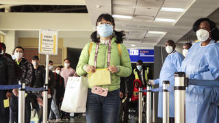 29.01.2020, Kenia, Nairobi: Passagiere, die von einem Flug aus China kommen, werden bei ihrer Ankunft am internationalen Flughafen Jomo Kenyatta auf den Coronavirus untersucht. Das Coronavirus hat sich bislang vor allem in China ausgebreitet. Außerhalb der Volksrepublik gibt es in anderen Ländern weltweit Erkrankte mit dem neuen Virus. Foto: Patrick Ngugi/AP/dpa +++ dpa-Bildfunk +++