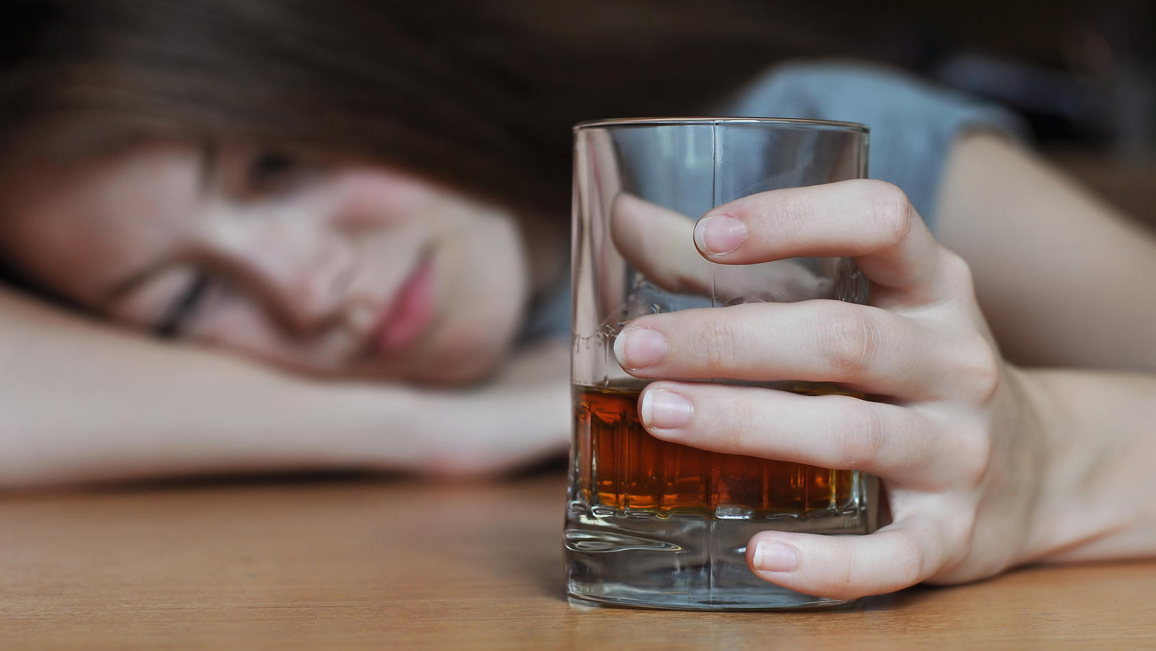 Betrunkene Frau mit einem Glas Whisky