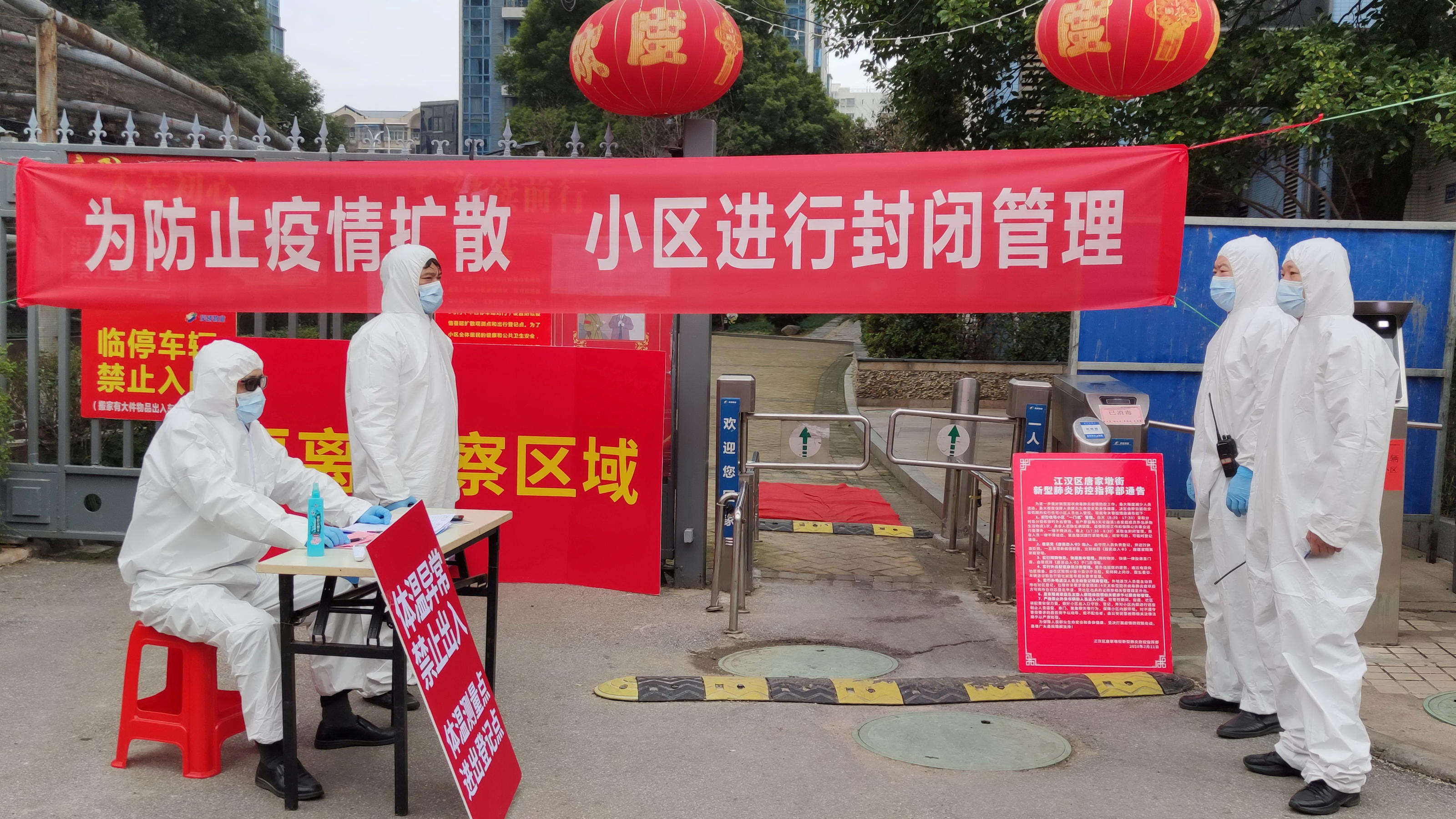FILE PHOTO: Workers in protective suits are seen at a checkpoint for registration and body temperature measurement, at an entrance to a residential compound in Wuhan, the epicentre of the novel coronavirus outbreak, in Hubei province, China February 