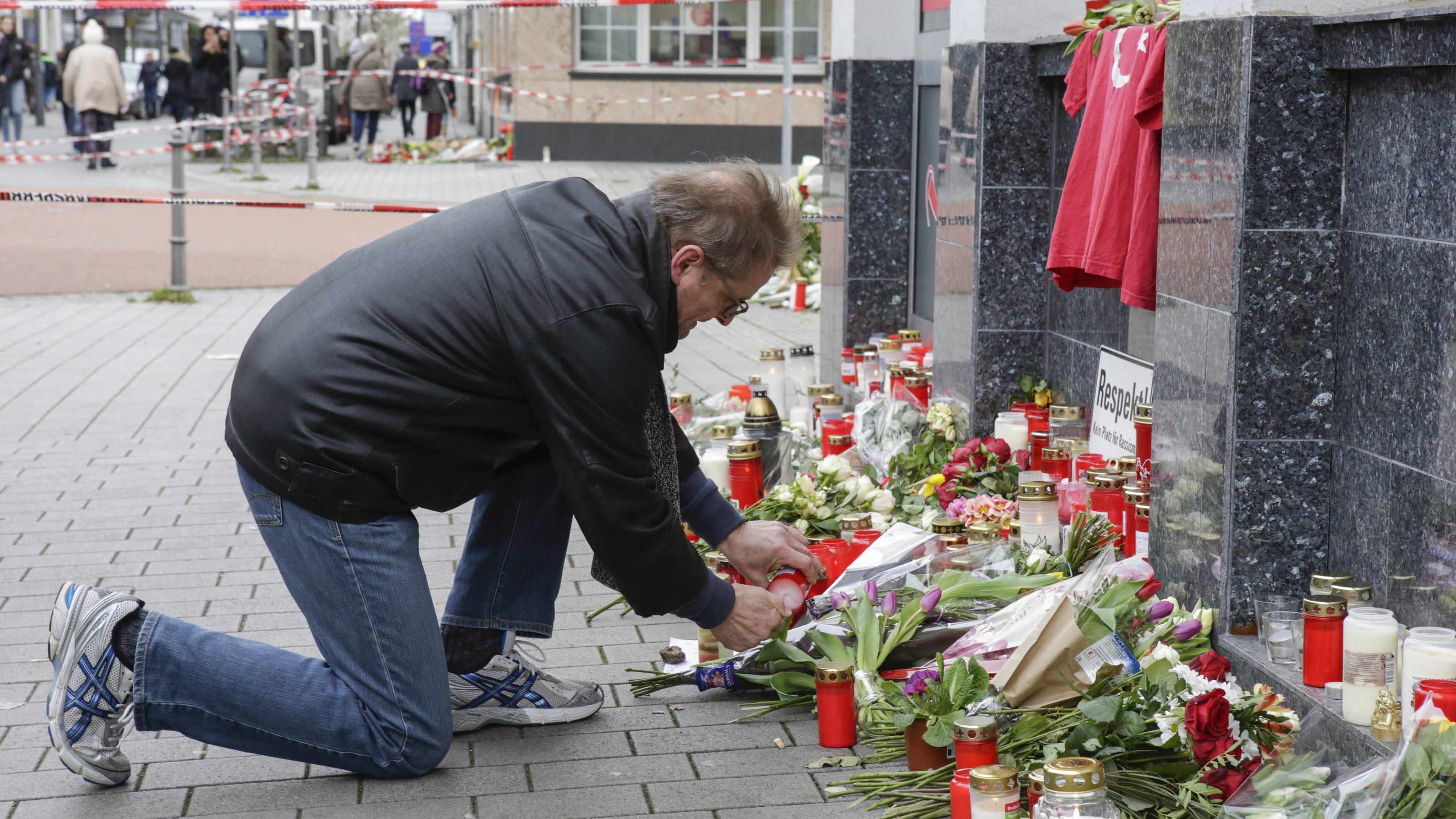 Germany: Anti-fascist protest in Hanau A mourner lays down a candle at one of the memorials for the Hanau shooting. Several thousand people marched through Hanau three days after the Hanau Shootings, to remember the victims and to protest against the