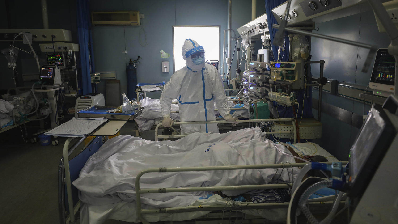 13.02.2020, China, Wuhan: Ein Arzt überprüft die Kodierungen eines Patienten im Krankenhaus Jinyintan, das für kritische Covid-19-Patienten vorgesehen ist.  Die schwer vom Coronavirus betroffene Provinz Hubei hat eingeräumt, dass es doch mehr Infizie