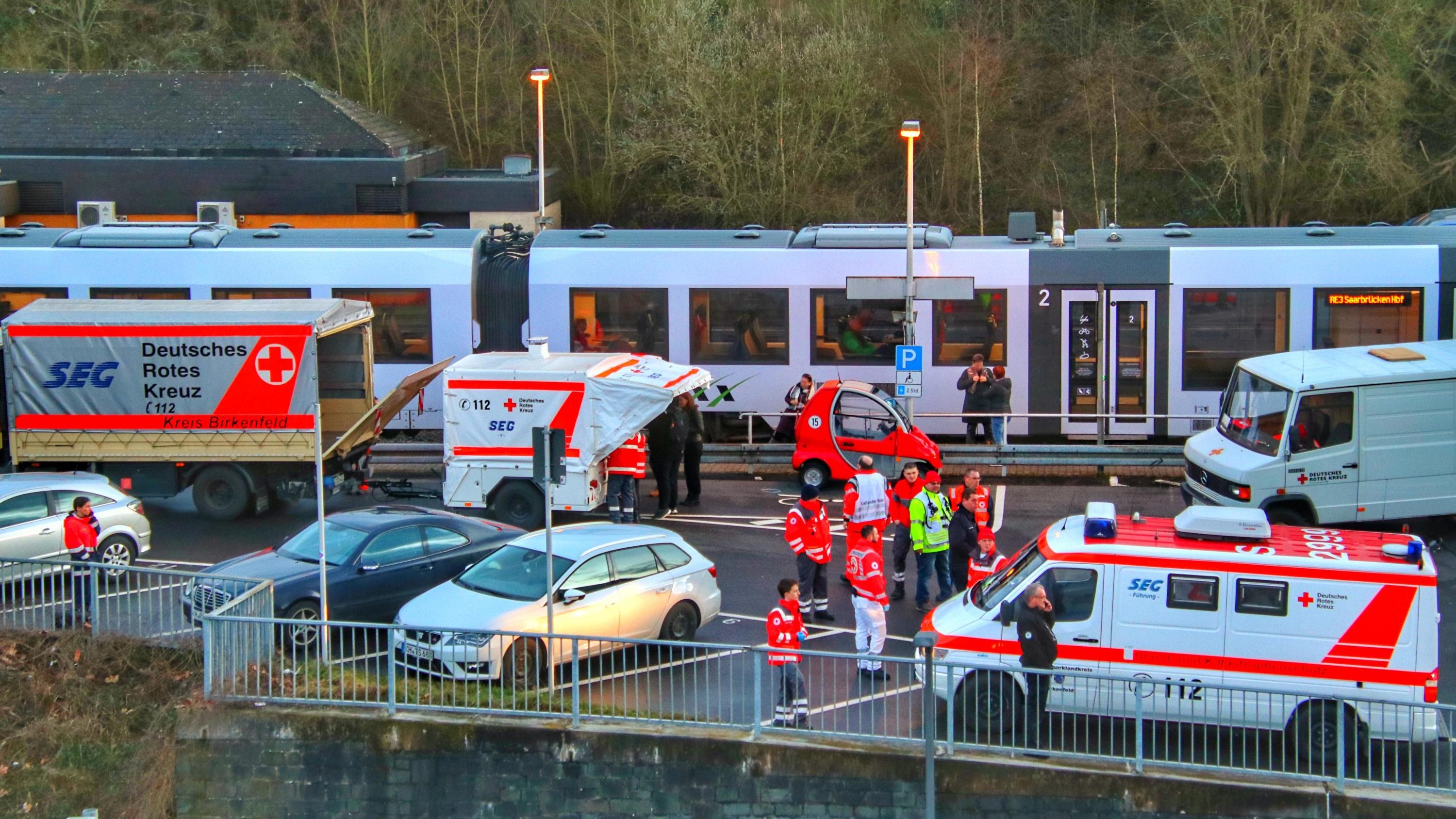 26.02.2020, Rheinland-Pfalz, Idar-Oberstein: Rettungssanitäter stehen am Bahnhof. Die Bundespolizei in Idar-Oberstein hatte hier einen Regionalzug mit etwa 70 Fahrgästen wegen Coronavirus-Verdachts gestoppt. Es habe einen Hinweis gegeben, dass ein Re