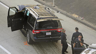 27.02.2020, USA, Los Angeles: Polizeibeamte stehen nach der Verfolgung eines gestohlenen Leichenwagens neben einem kaputten Auto auf einer Autobahn. Der Diebstahl eines Leichenwagens samt Leiche in einem Sarg ist in Kalifornien nach einer Verfolgungsjagd mit einer Festnahme zu Ende gegangen. Foto: Reed Saxon/AP/dpa +++ dpa-Bildfunk +++