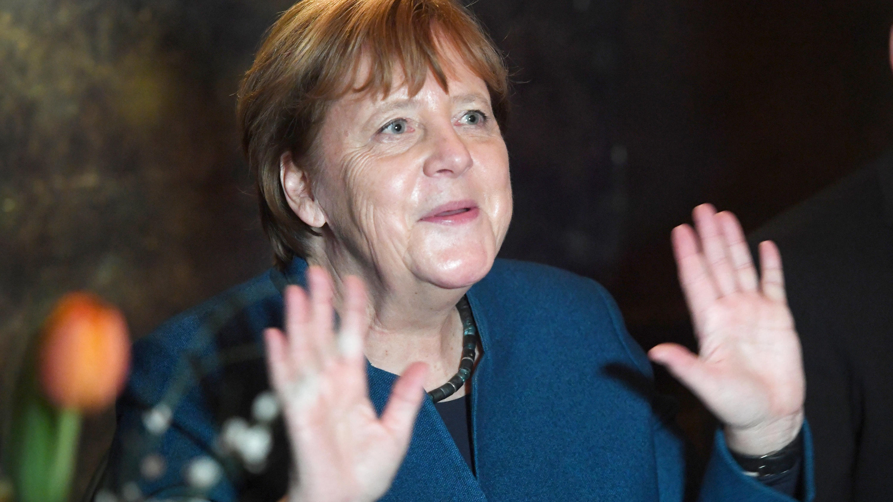 28.02.2020, Mecklenburg-Vorpommern, Stralsund: Bundeskanzlerin Angela Merkel (CDU) hebt auf dem Jahresempfang ihres Wahlkreises beide Hände hoch, um zu zeigen, dass sie niemandem die Hand geben möchte aufgrund einer möglichen Ansteckungsgefahr durch 