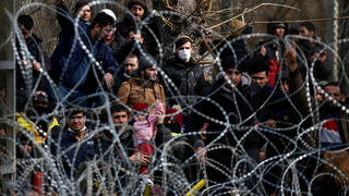 02.03.2020, Griechenland, Kastanies: Migranten stehen hinter einem Stacheldrahtzaun nahe des griechisch-türkischen Grenzübergangs von Kastanies. Tausende Migranten und Flüchtlingen sammelten sich an der Westgrenze der Türkei und versuchten, auf dem Land- und Seeweg nach Griechenland zu gelangen, nachdem der türkische Präsident Erdogan verkündet hatte, dass ihre Grenzen für diejenigen offen seien, die nach Europa gehen wollten. Foto: Giannis Papanikos/AP/dpa +++ dpa-Bildfunk +++