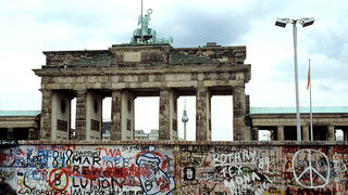 Die Berliner Mauer von der Westseite am Brandenburger Tor Ende August 1989. Auf der Westseite ist die Mauer mit bunten Graffiti bemalt. Foto: Sven Barten