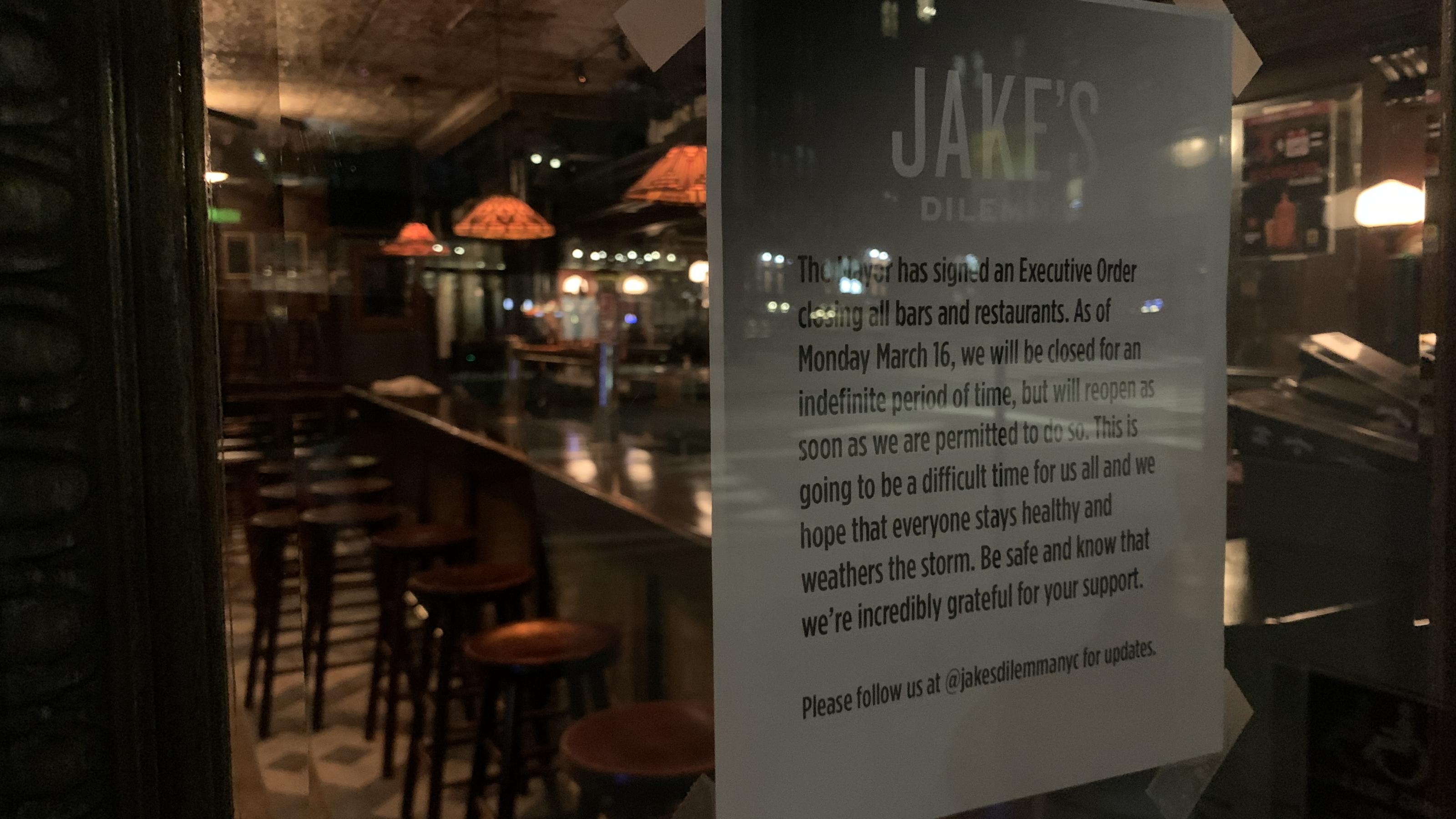 New York City: Bar geschlossen, Hinweisschild an der Tür, ungenutzte Barhocker