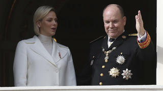 FILE - In this Nov.19, 2019 file photo Prince Albert II of Monaco with his wife Princess Charlene wave from the balcony during the ceremony marking the National Day in Monaco. The palace of Monaco says Prince Albert II has tested positive for the new coronavirus but his health is not worrying. For most people, the new coronavirus causes only mild or moderate symptoms. For some it can cause more severe illness. (AP Photo/Daniel Cole, File)