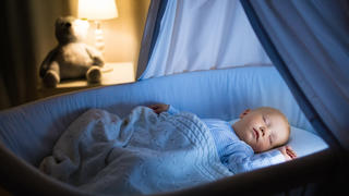Baby macht ein geruhsames Schläfchen in der Babywiege
