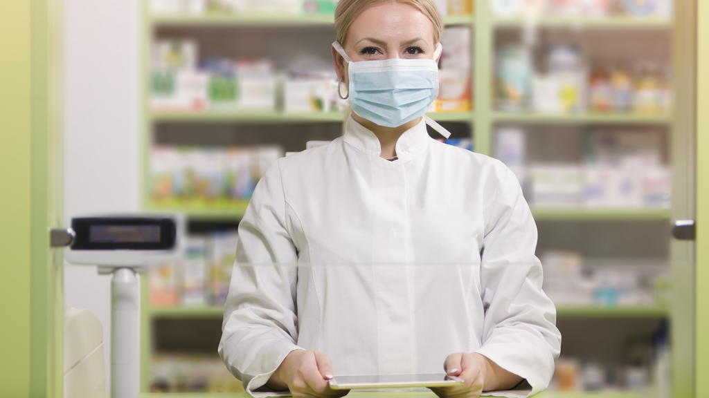 Apothekerin schützt sich mit Gesichtsmaske - Podcast zum Coronavirus