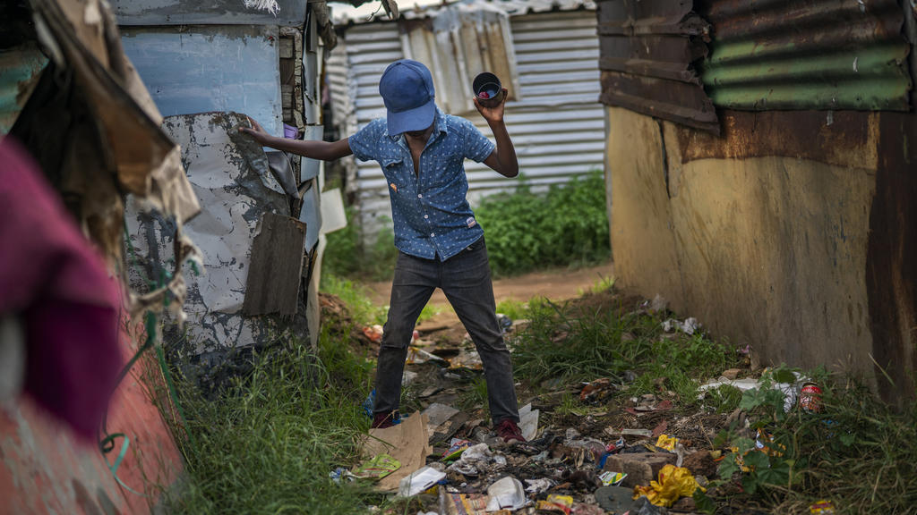Südafrika, Soweto: Ein Kind geht über Müll in dem Armenviertel Empiweni.