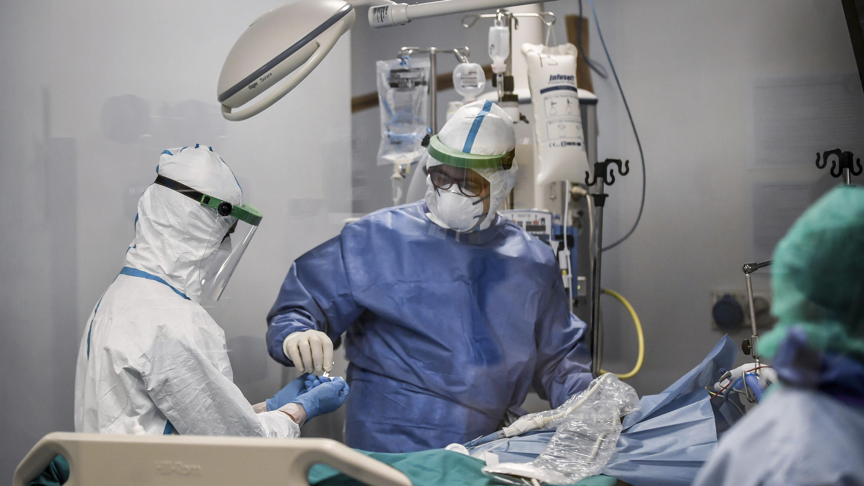 26.03.2020, Italien, Pavia: Ärzte versorgen einen Patienten auf der Covid-19-Intensivstation des San Matteo Krankenhauses. Foto: Claudio Furlan/LaPresse/AP/dpa +++ dpa-Bildfunk +++