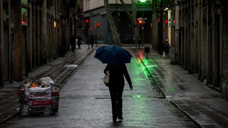  March 30, 2020, Barcelona, Catalonia, Spain: A woman walks the empty streets of Barcelona downtown under the rain. Daily coronavirus deaths fall slightly with 812 Covid-19 victims in the last 24 hours in Spain, Spanish government has ordered new lockdown restrictions. Barcelona Spain - ZUMAb137 20200330zapb137015 Copyright: xJordixBoixareux