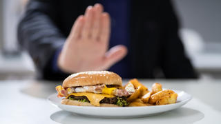 Cholesterin senken: Mann lehnt Burger und Pommes ab