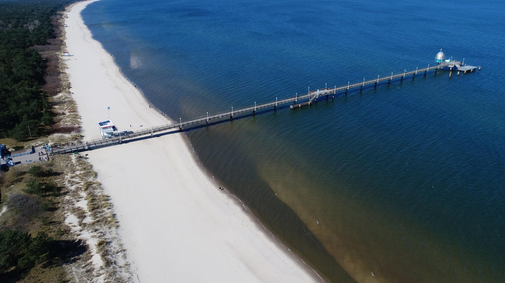 05.04.2020, Mecklenburg-Vorpommern, Zinnowitz: Menschenleer ist die Strandpromenade mit der Seebrücke im Ostseebad Zinnowitz auf der Insel Usedom (Luftaufnahme mit einer Drohne). Wegen der scharfen Einschränkungen im öffentlichen Leben wird der tradi