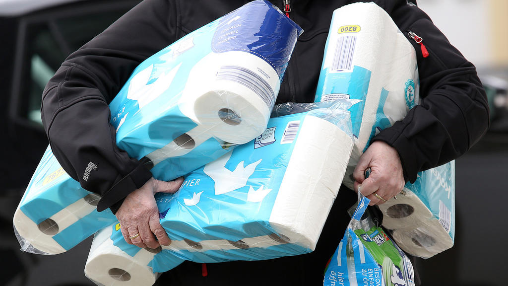 ARCHIV - 18.03.2020, Nordrhein-Westfalen, Siegen: Ein Mann trägt eingekauftes Toilettenpapier und Küchenrollen aus einem Supermarkt. Der Verkauf von Toilettenpapier ist in der vergangenen Woche drastisch zurückgegangen. Erstmals seit Beginn der Coron