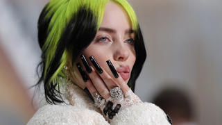 FILE - In this Feb. 9, 2020 file photo, singer Billie Eilish arrives at the Oscars in Los Angeles. The Elton John-led starry benefit concert that featured Eilish, Mariah Carey and Alicia Keys on Sunday has raised nearly $8 million to battle the coronavirus. The musicians performed from their homes for the hour-long event that aired on Fox and iHeartMedia radio stations. Fox will re-broadcast the concert on Monday, April 6. (AP Photo/John Locher, File)