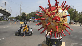 Indian police placed a virus themed globe at a traffic signal aimed at creating awareness about the new coronavirus in Hyderabad, India, Thursday, April 9, 2020. The new coronavirus causes mild or moderate symptoms for most people, but for some, especially older adults and people with existing health problems, it can cause more severe illness or death. (AP Photo/Mahesh Kumar A.)