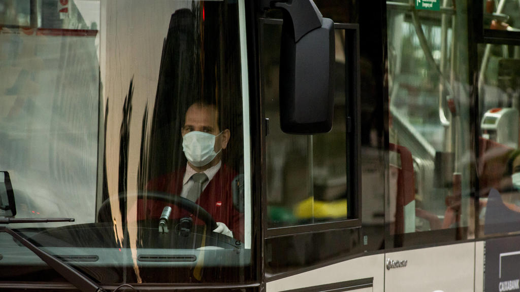 April 7, 2020, Barcelona, Catalonia, Spain: A bus driver wearing a protective face mask waits for the traffic light to turn green in Barcelona. After four-day fall, daily coronavirus deaths in Spain rise to 743. The total number of fatalities in the