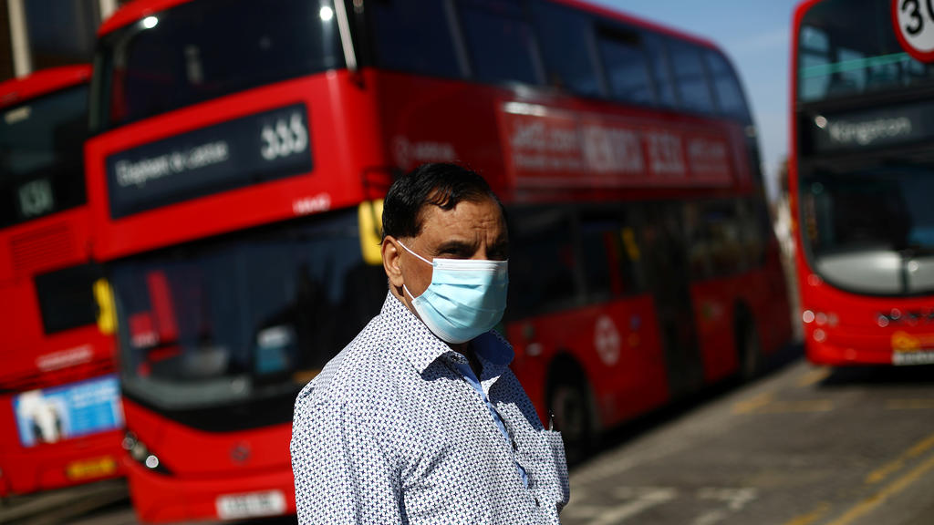 A man is seen wearing a protective face mask at a bus station as the spread of coronavirus disease (COVID-19) continues in London, Britain, April 15, 2020. REUTERS/Hannah McKay