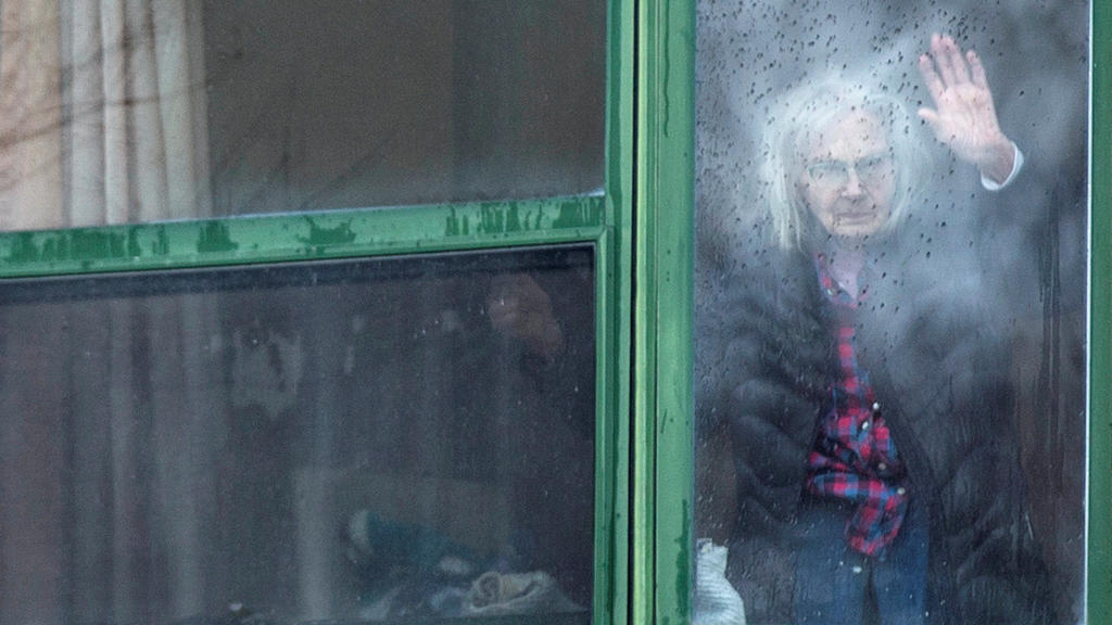 A resident waves from her window at Residence Herron, a senior's long-term care facility, following a number of deaths since the coronavirus disease (COVID-19) outbreak, in the suburb of Dorval in Montreal Quebec, Canada, April 13, 2020. REUTERS/Chr