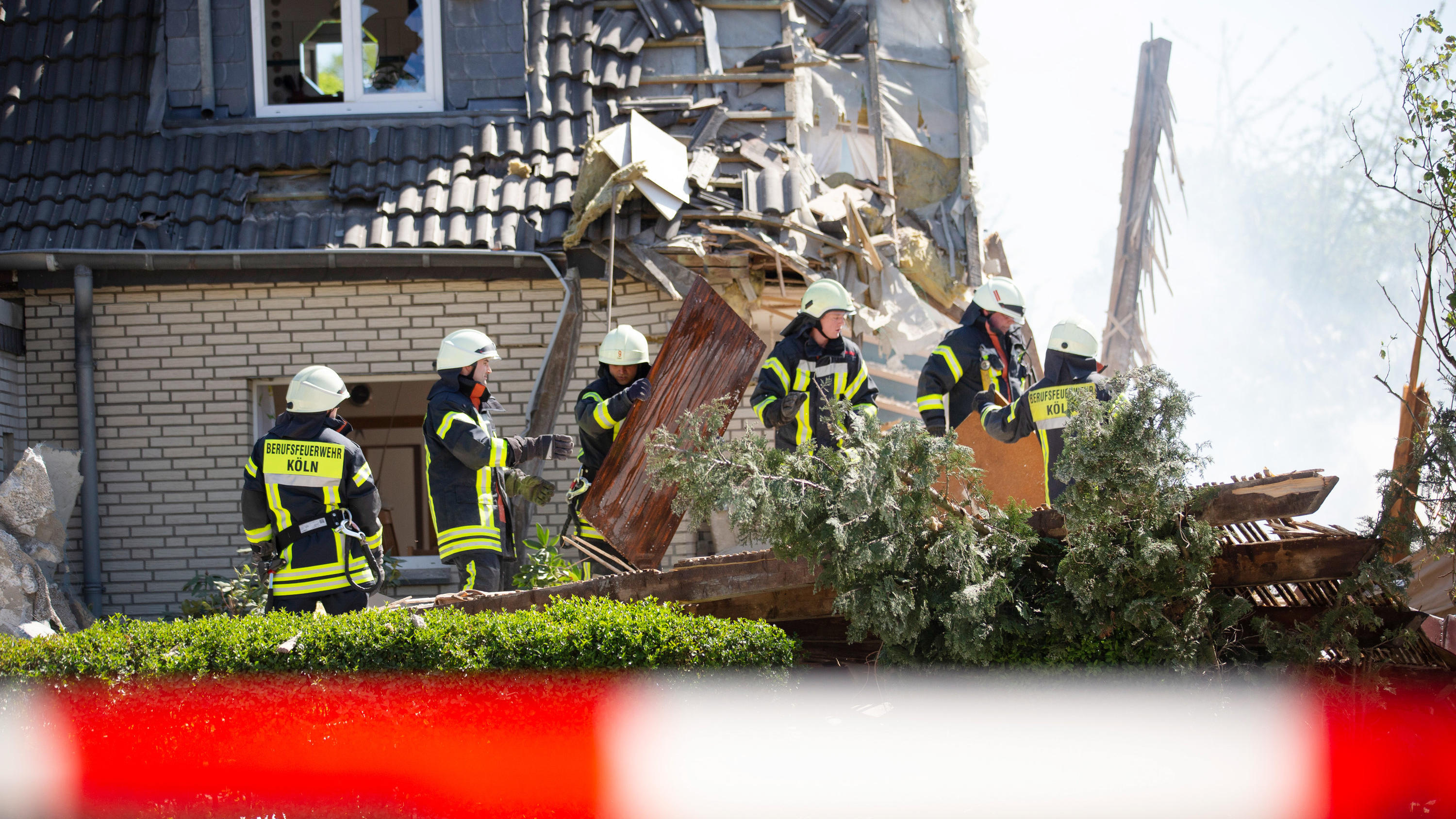 Köln: Doppelhaushälfte nach Explosion eingestürzt - Feuerwehrleute am Unfallort