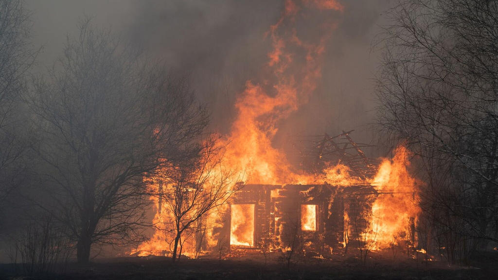 A view shows a wooden house on fire, as an operation to extinguish wildfires around the defunct Chernobyl nuclear plant continues, in Lyudvynivka in Kiev Region, Ukraine April 18, 2020. Picture taken April 18, 2020. REUTERS/Volodymyr Shuvayev