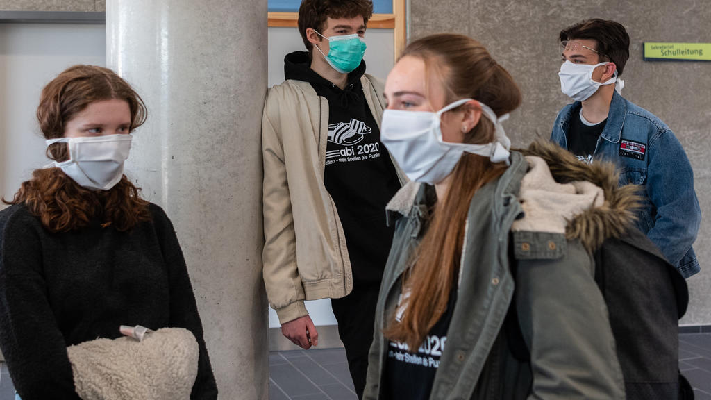 20.04.2020, Sachsen, Dresden: Abiturienten am Gymnasium Dresden Klotzsche stehen vor Beginn der Konsultationen im Treppenhaus und tragen einen Mundschutz. Nach einem Monat weitgehenden Stillstands wegen der Eindämmung des Coronavirus in Deutschland w