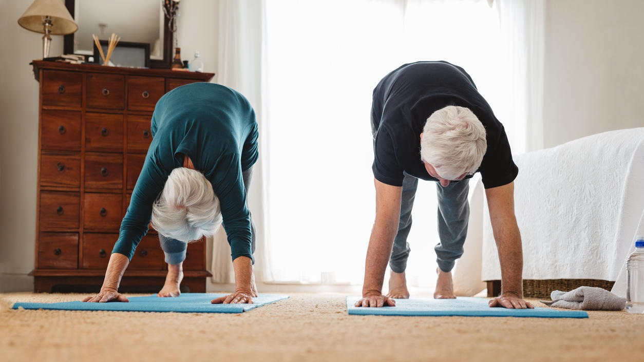 Älteres Paar macht zu Hause Yoga