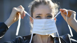 Frau legt Mundschutzmaske an, Portrait, Corona-Krise, Stuttgart, Baden-Württemberg, Deutschland Coronavirus *** Woman putting on face mask, portrait, corona crisis, Stuttgart, Baden Württemberg, Germany Coronavirus 