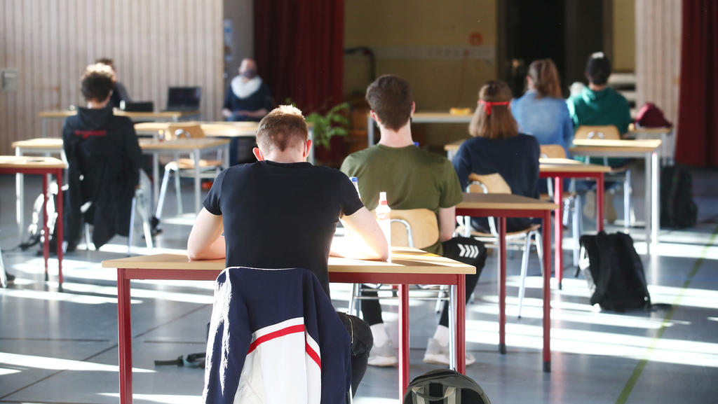 27.04.2020, Thüringen, Jena: Schüler mit Mundschutz sitzen bei der Prüfungsvorbereitung fürs Abitur in einer zum Schulraum umfunktionierten Turnhalle in der JenaPlan Schule. Nach einer mehrwöchigen Corona-Zwangspause öffnen die Schulen am 27.04.2020