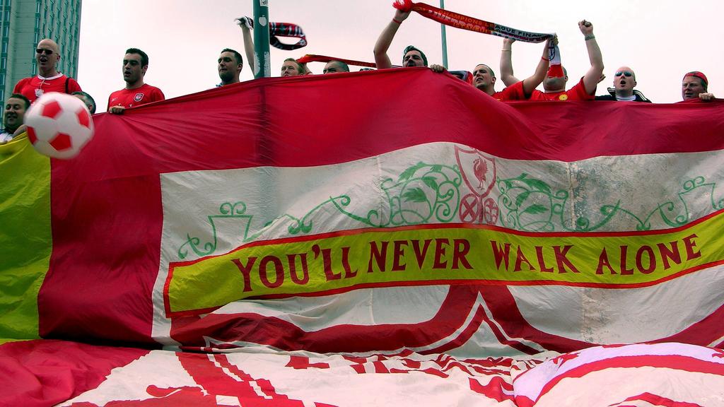 Liverpooler Fans mit einer riesigen Vereinsfahne, auf der die Vereinshymne zu lesen ist: You ll never walk alone