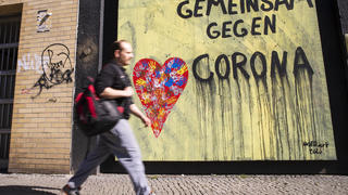 Mann laeuft vor einem Grafitti Gemeinsam gegen Corona in Berlin am 22. April 2020. Ab heute koennen in Berlin laeden unter 800 qm, Buchhandlucngen und Autosalons wieder oeffnen mit Einhanltung von Hygiene und Distanzvorschriften. Coronavirus in Berlin *** Man runs in front of a graffiti Together against Corona in Berlin on April 22, 2020 From today on, bookstores and car showrooms under 800 sqm in Berlin can reopen with compliance of hygiene and distance regulations Coronavirus in Berlin 