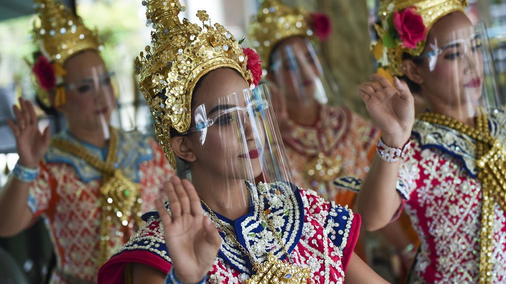 In der thailändischen Hauptstadt Bangkok tanzen Frauen mit Gesichtsschutz.