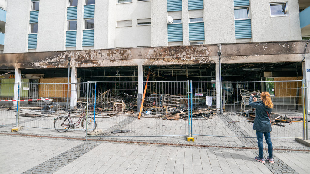 30.04.2020, Bayern, Waldkraiburg: Eine Frau fotografiert die Zerstörung, die ein Brand in einem türkischen Geschäft angerichtet hat. Eine Sonderkommission ermittelt unter der Leitung der Zentralstelle zur Bekämpfung von Extremismus und Terrorismus (Z