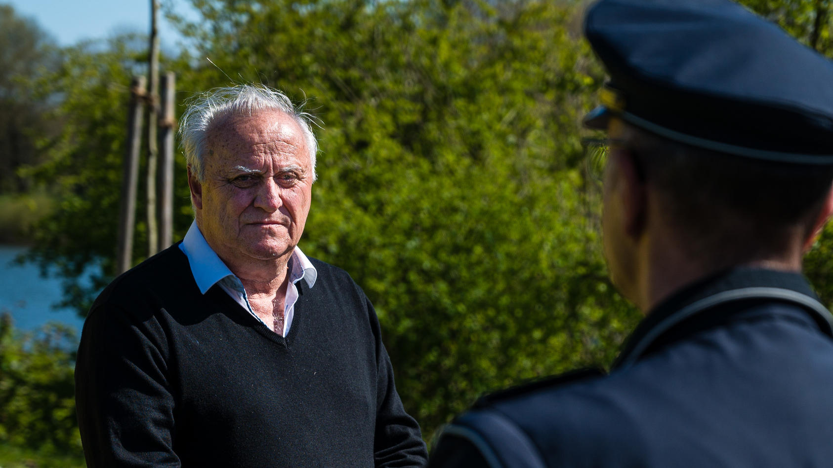 Klaus Bouillon (CDU), saarländischer Innenminister, informiert sich bei einem Polizisten über die Lage an den Grünflächen der Stadt Saarbrücken.