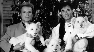 ARCHIV - 30.11.1999, USA, Las Vegas: Die deutschen Magier Siegfried (l) und Roy sitzen im Dezember 1999 in Las Vegas (USA) vor einem Weihnachtsbaum. «Siegfried & Roy»-Magier Roy Horn ist in Las Vegas an den Folgen von Covid-19 gestorben. Foto: Fotoreport Shandwick/dpa +++ dpa-Bildfunk +++