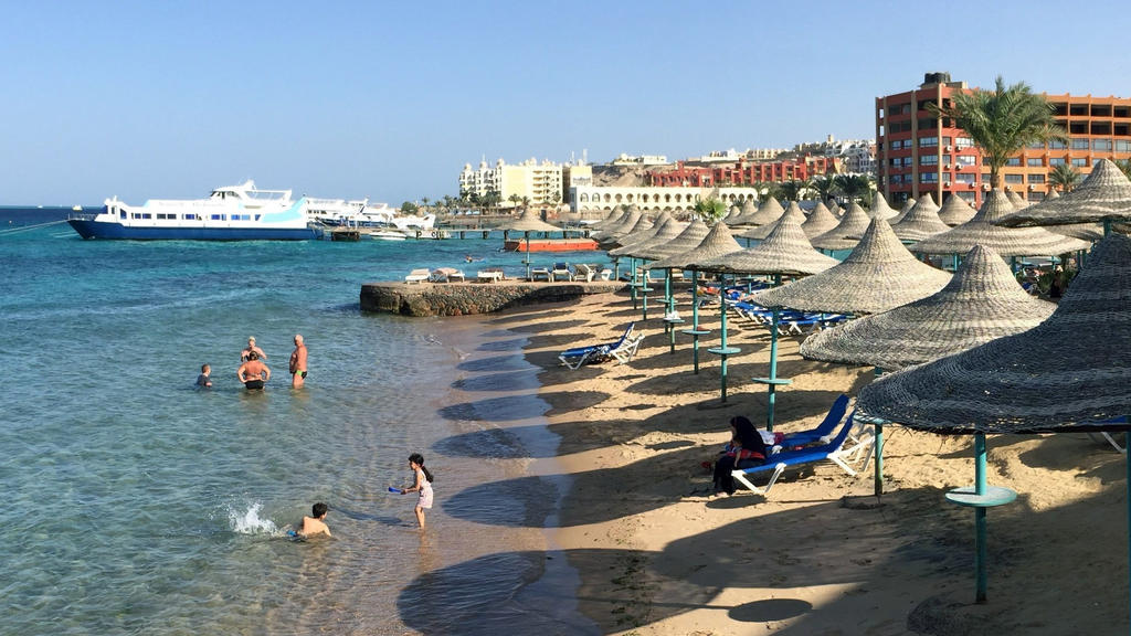 ARCHIV - 22.05.2016, Ägypten, Hurghada: Touristen stehen im Wasser an einem Hotel-Strand in Hurghada. (Zu dpa "Reisebranche wehrt sich gegen «pauschalen Abgesang» auf Sommerurlaub") Foto: picture alliance / Benno Schwinghammer/dpa +++ dpa-Bildfunk ++