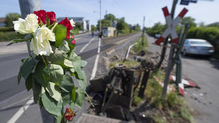 08.05.2020, Hessen, Frankfurt/Main: Blumen stecken am Unglücksort an einem Bahnübergang im Stadtteil Nied, wo am Vortag bei einem Unfall eine 16-Jährige tödlich verletzt worden war. Nach bisherigen Ermittlungen waren die Schranken zum Zeitpunkt des Unglücks nicht geschlossen. Foto: Boris Roessler/dpa +++ dpa-Bildfunk +++