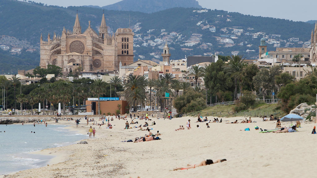 25.05.2020, Spanien, Palma De Mallorca: Badegäste liegen am Strand Playa de Palma. Nach einer mehr als zweimonatigen Zwangsschließung wegen der Corona-Pandemie haben Mallorca und viele andere Regionen Spaniens am Montag ihre Strände wieder geöffnet. 