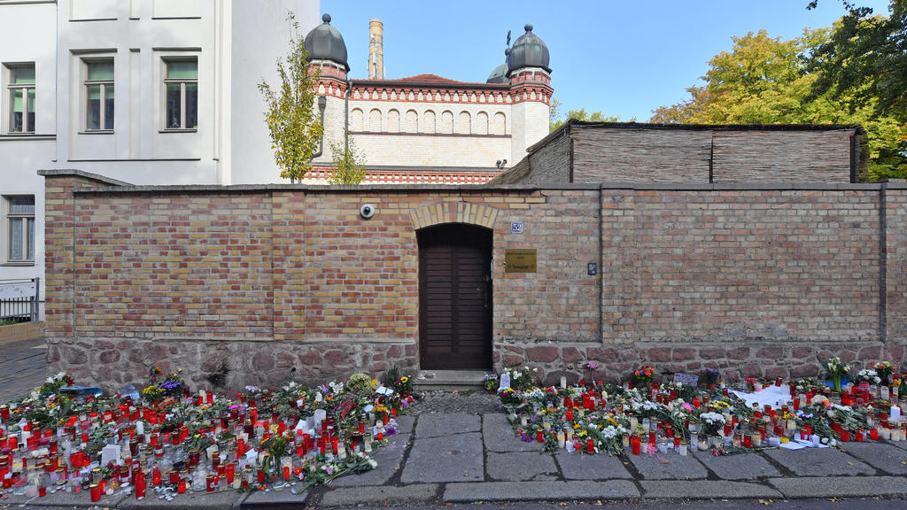 ARCHIV - 13.10.2019, Sachsen-Anhalt, Halle (Saale): Blumen und Kerzen stehen neben der Tür zur Synagoge, vier Tage nach dem rechtsextremistischen Anschlag auf die Gemeinde. Bundesinnenminister Seehofer und BKA-Präsident Münch stellen am Mittwoch in B