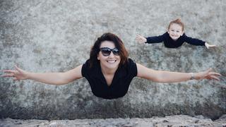 Mother and daughter with arms outstretched, Top view photo of cheerful mother wearing casual clothes and her sweet adorable daughter are looking up to the camera