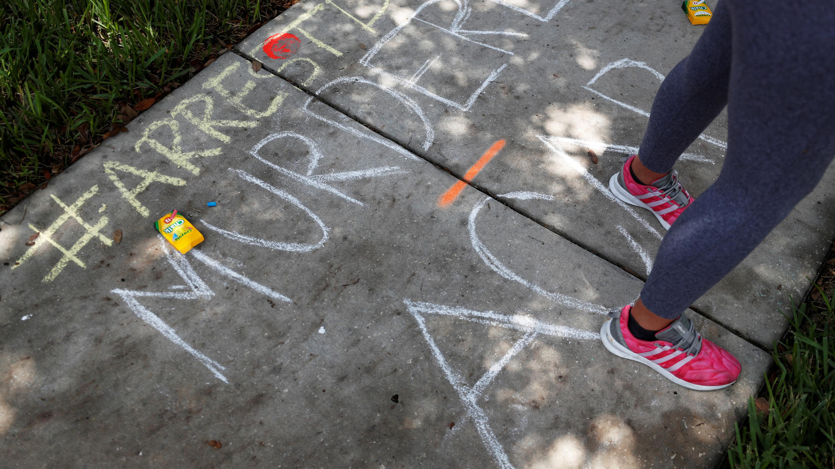 Chalk markings done by protesters cover the sidewalk outside the Florida home of former Minneapolis police officer Derek Chauvin, in Orlando