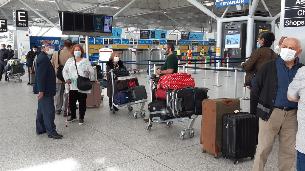 03.06.2020, Großbritannien, Stansted: Passagiere stehen am Flughafen Stansted Essex Schlange für einen Flug nach Adana in der Türkei. Geplant war bisher, vom 8. Juni an eine zweiwöchige Quarantäne für alle Reisenden einzuführen, die nach Großbriannie